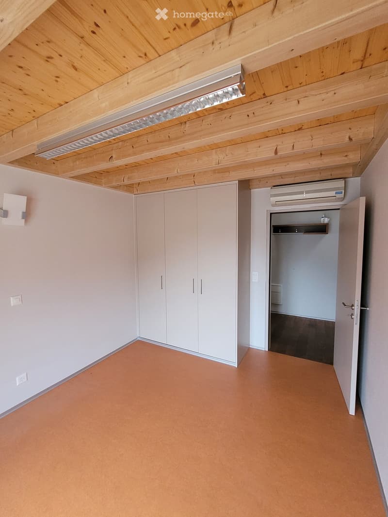 empty room, white walls, orange floor, ceiling with wooden beams, wardrobe, door, air conditioning