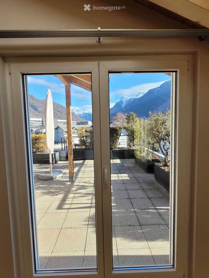 French door showing a balcony area with a mountain view