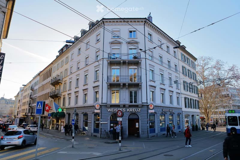 5 story corner house, white exterior, balcony, large sign saying 'Weisse Kreuz'