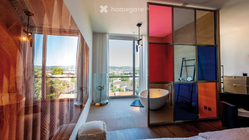 Bathroom with tub, color panels, large windows, wooden floor