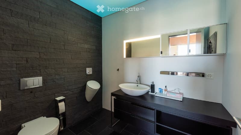contemporary bathroom with black tile floor, silver and black fixtures, modern sink, silver and black mirrors, recessed lighting