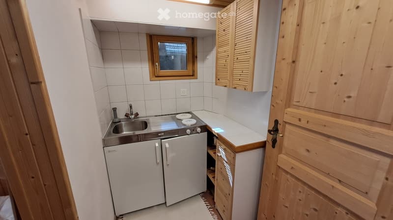 wooden cabinets, white walls, tiled floor, stainless steel sink, dishwasher, washing machine, small gas stove