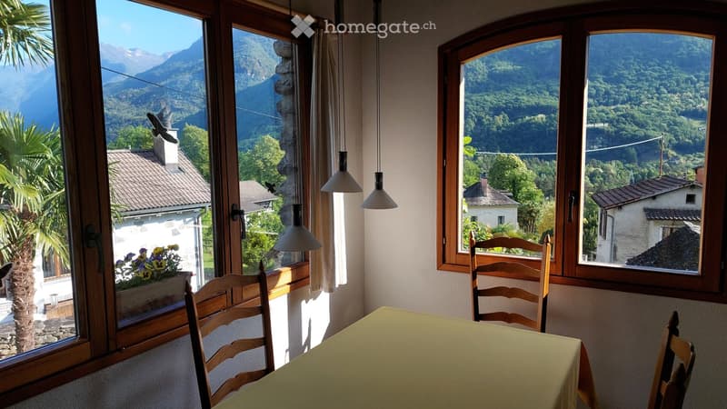 Dinning room with table and chairs, large windows with mountain view