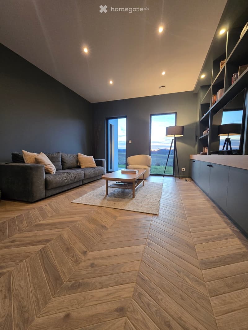 Wooden floor, large windows, sofa, armchair, coffee table, lamps, shelves, couch