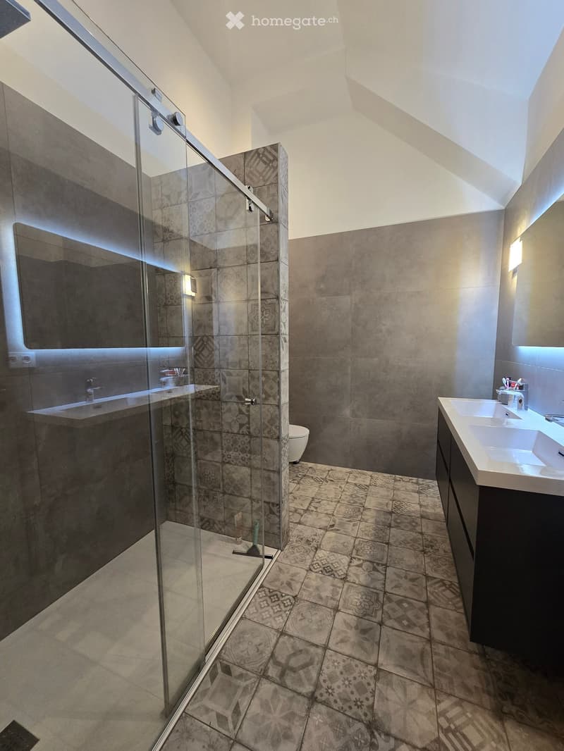 modern bathroom, glass walk-in shower, double vanity, grey tiled floor, white ceramic walls, LED lighting
