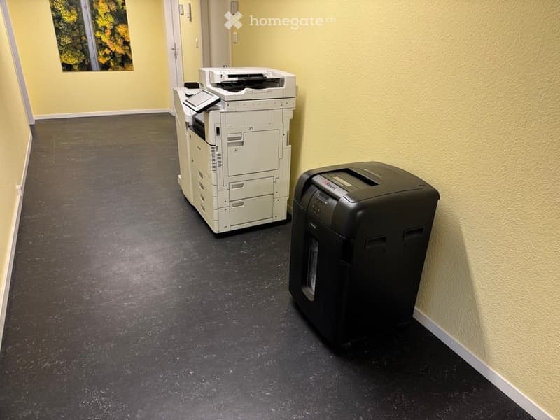empty room with yellow walls, a white office copier, and a black shredder