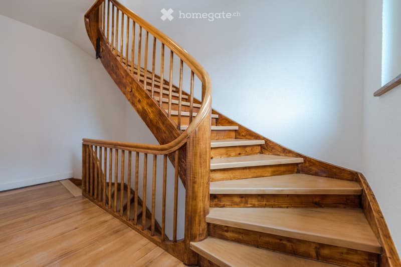 Wooden staircase with white painted wall