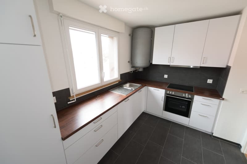 white cabinetry, wooden countertops, stainless steel sink, oven, gas stove, dishwasher, tiled flooring, window with view