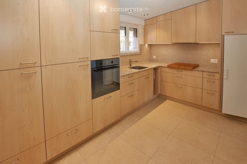 Modern kitchen, with wooden cabinets, tiled flooring, granite countertops, modern appliances, sink with faucet, window with white curtains