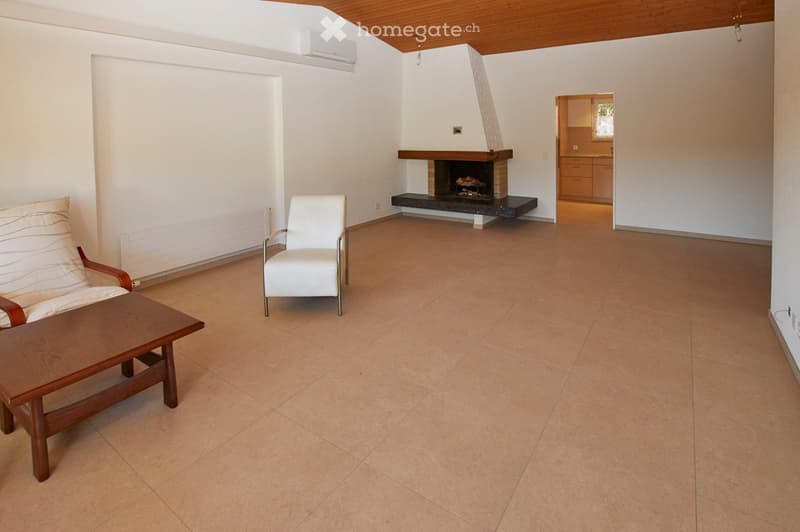 white tile flooring, central fireplace, modern white armchair, couch, wood table