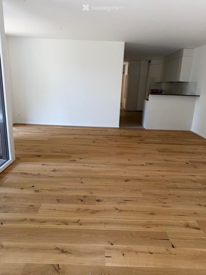 Completely empty room with light wooden flooring and white walls. No furniture or equipment visible.