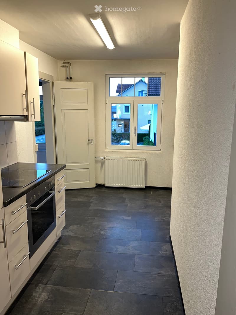 modern kitchen, stove top, built-in oven, window, radiator, dark tile flooring