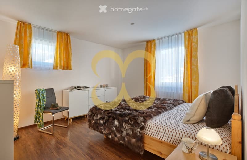 bedroom with bed, bed covers, pillows, lamps, nightstand, chair, cabinet with books, curtains, wooden floor, standing lamp
