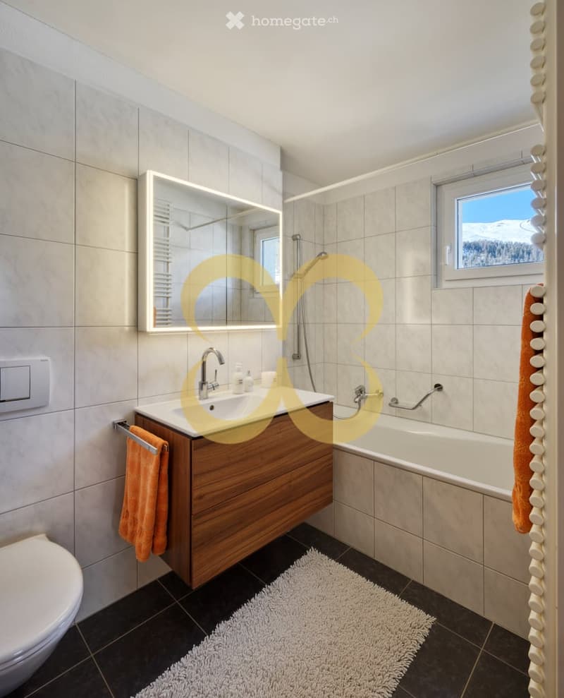 Bathroom with sink, mirror, bathtub, toilet, towel, and window