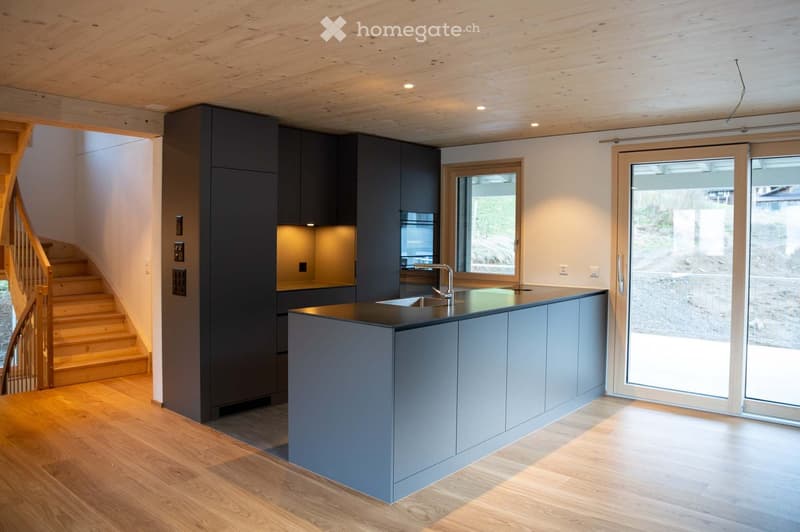 modern kitchen with island, wooden staircase, large windows, integrated appliances