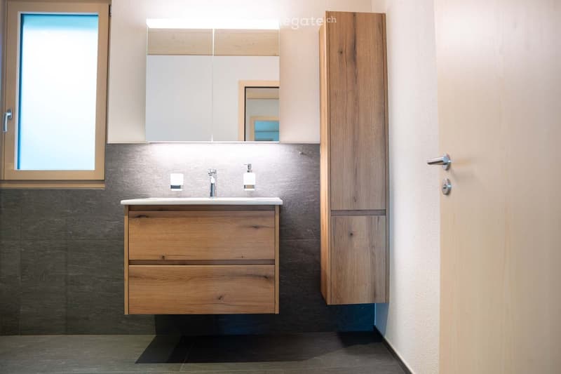 wooden vanity, silver sink, mirror, tiled walls, glass window