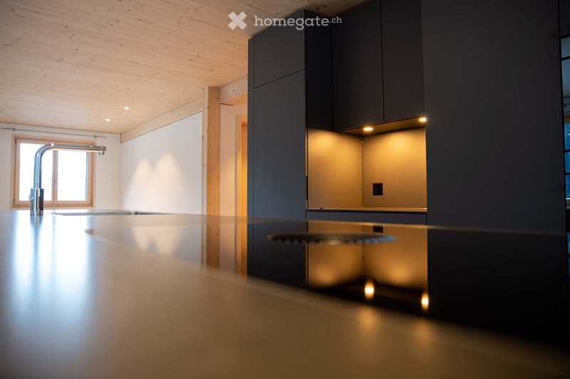 modern kitchen, island with double sink, stainless steel faucet, wooden ceiling, black cabinetry, lit undercabinet lights