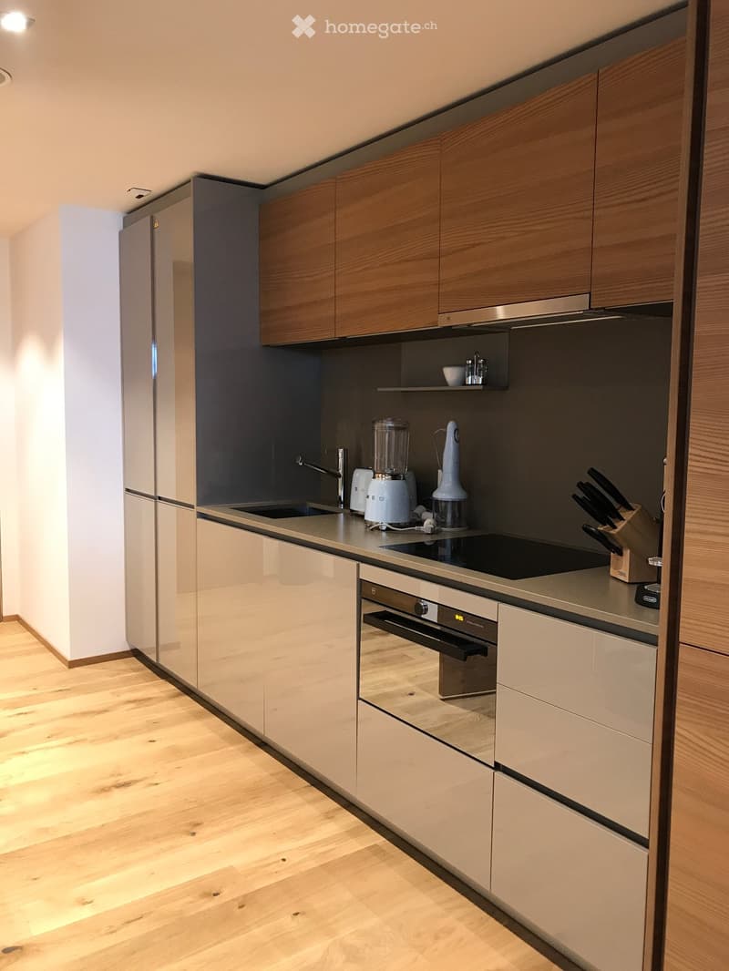 modern kitchen, wooden floor, white walls, stainless steel appliances, oven, dishwasher, fridge, wooden cabinets, wooden drawers, wooden countertops, black induction stove
