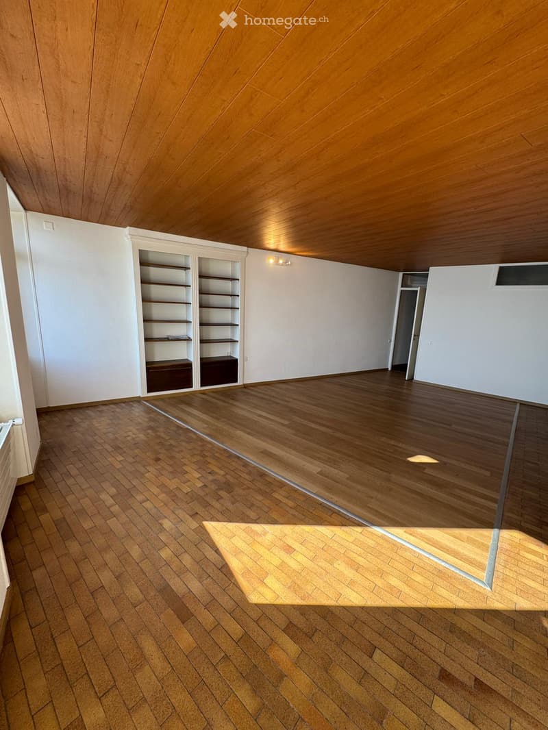 wooden flooring, high ceiling, white walls, empty shelves, door