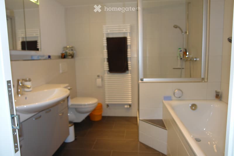 white tiles, modern bathroom, white bathtub, shower, toilet, sink, towel rack, mirror, cabinets