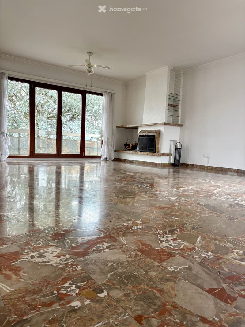Open room with marble floor, sliding doors, balcony, fireplace, white ceiling, ceiling fan, windows with curtains