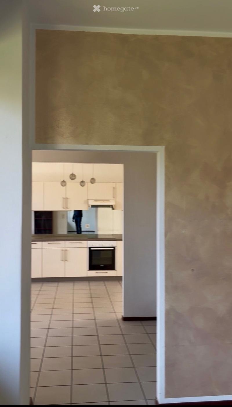 empty room, beige walls, tiled floor, white kitchen, integrated oven, large mirror
