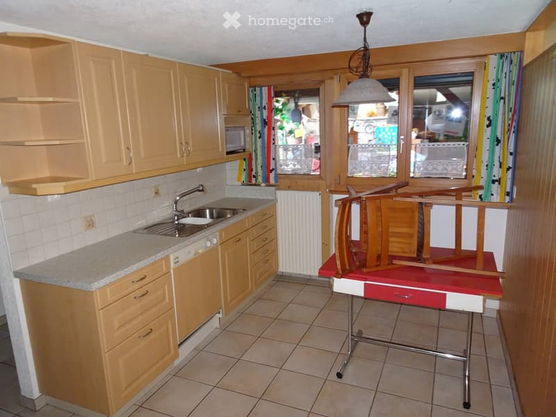 Kitchen, with wooden cabinets, white tiled floor, sink, and dishwasher