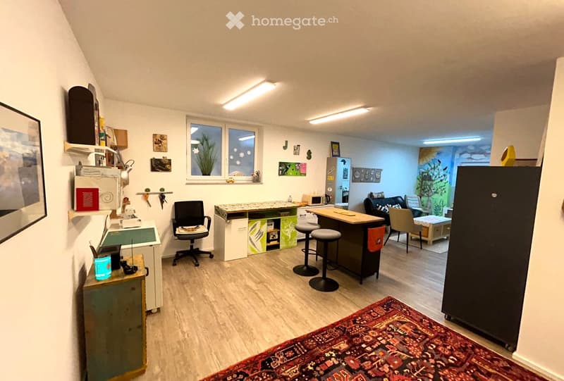 modern workspace with various tools, wooden floor, kitchen island with stools, shelves, large rug