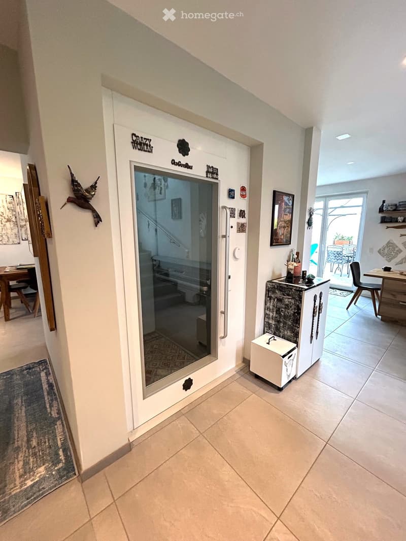 tiled floor, white wall, glass door, dining table, chairs, art frames, storage box, rug