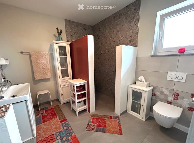 white sink, modern cabinet, white floor tile, walk in shower, toilet, window