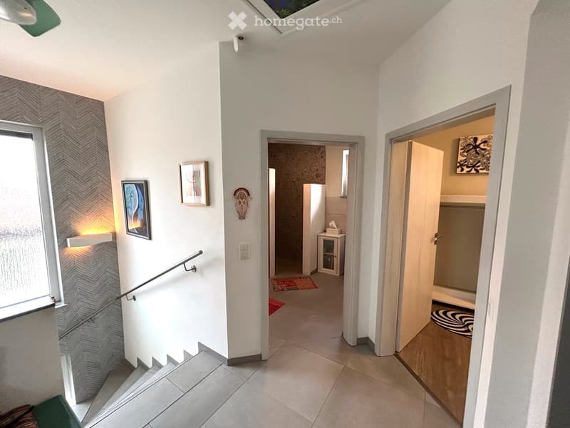 tiled floor, white walls, staircase, handrail, paintings, rug, sliding doors