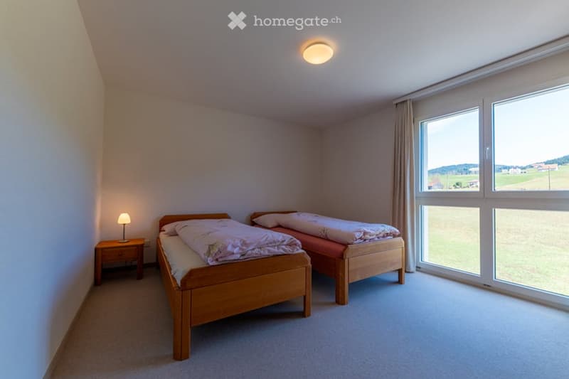 two beds, large window, lamp, carpet