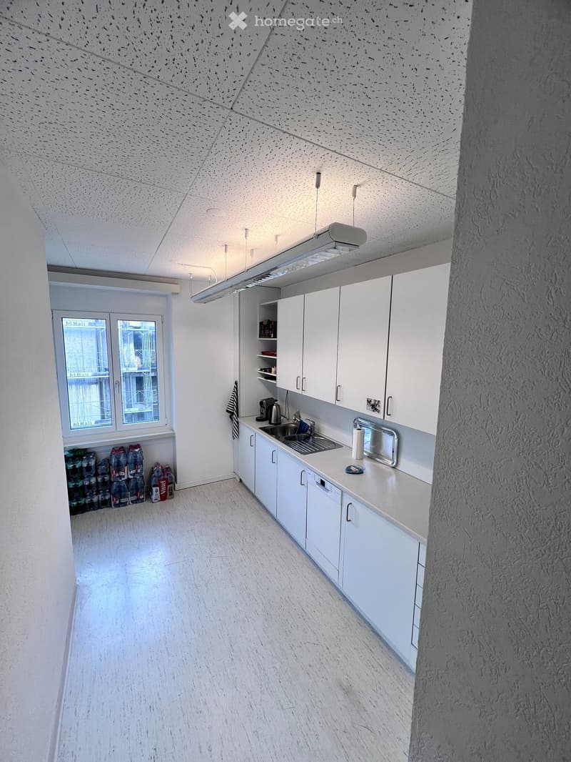 Empty kitchen with cabinets, sink, appliances, a window, and empty shelves