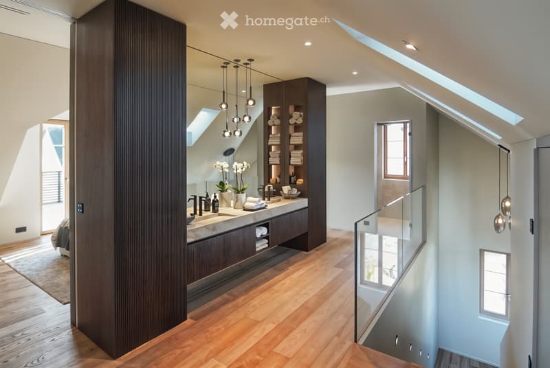 Master bathroom with modern fittings, large vanity, large mirror, skylights, stairs leading to upper floor