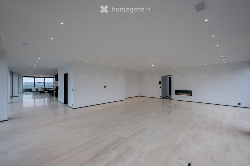 Open room with large white walls, fireplace on the wall and modern minimalistic style