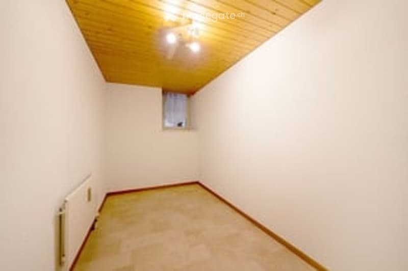 empty room, white walls, wooden ceiling, small window, radiator