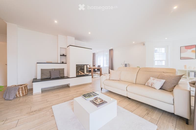 white walls, wooden floor, white couch, coffee table, fireplace, white rug, basket, books