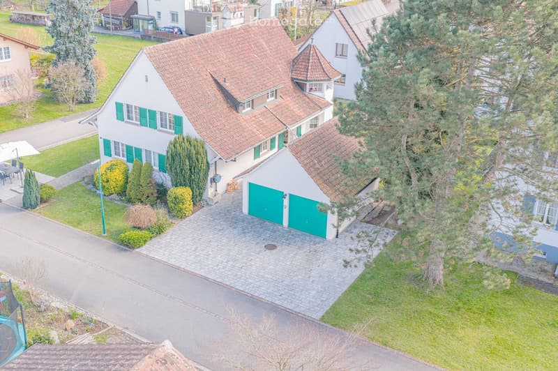 2 story house, brown roof, green shutters, driveway, garage