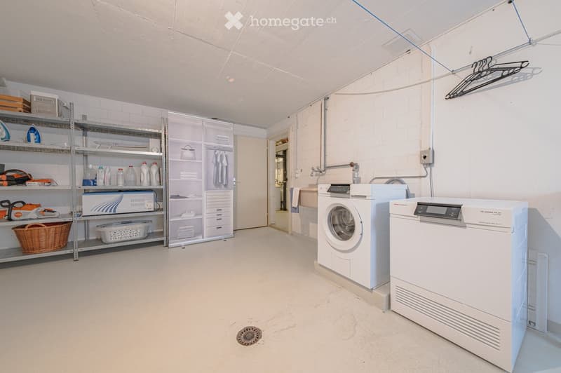 Laundry room with washing machine, dryer, shelves, and storage boxes