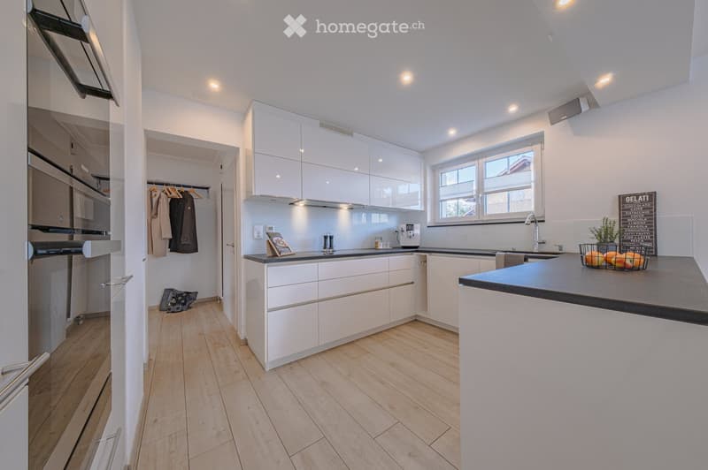 modern kitchen with white cabinets, wooden floor, granite countertop, sink, faucet, coffee machine, fruits in basket, window