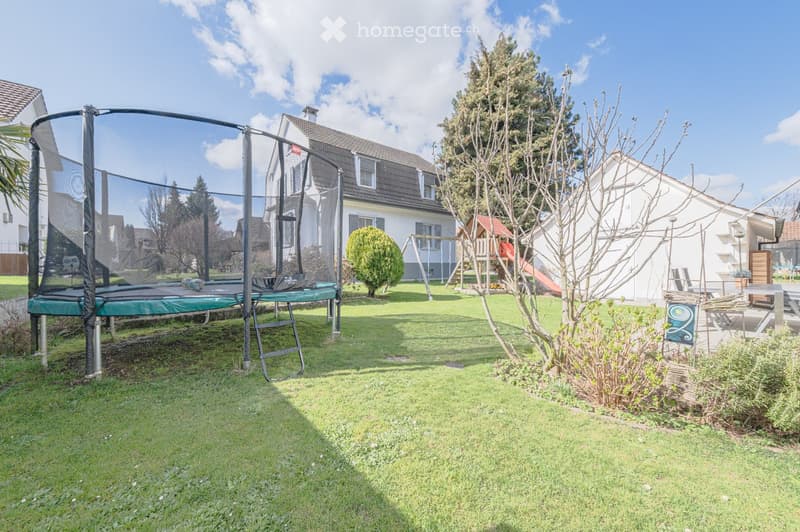 backyard with trampoline, swing, slide, and a small house
