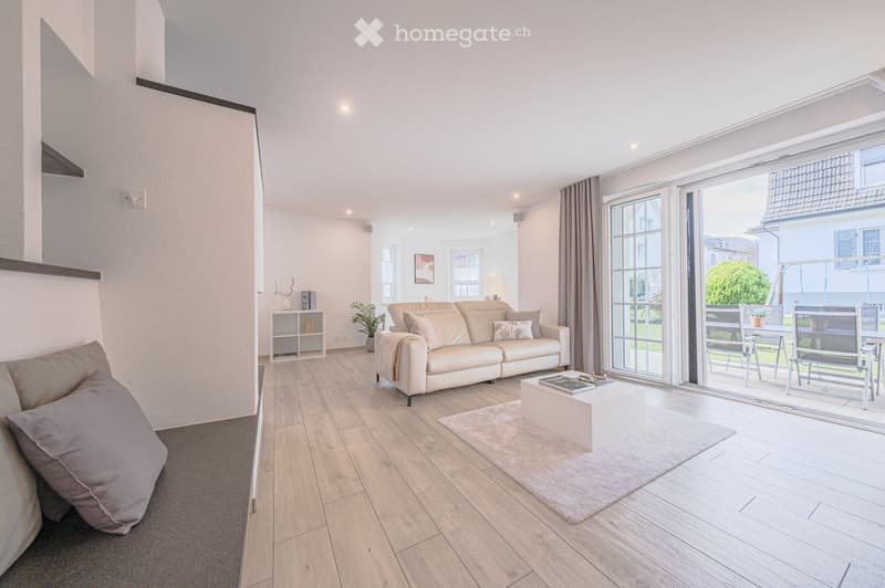 modern living room, white couch, coffee table, carpet, sliding glass doors, garden view