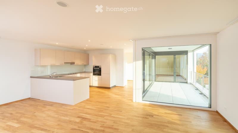 modern kitchen with island, white cabinets, wooden floor, large sliding glass door to balcony
