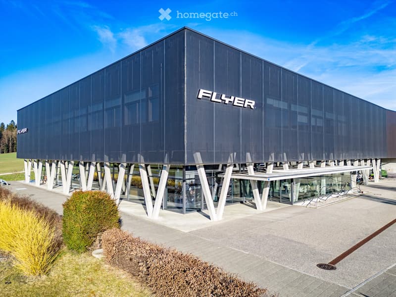 Modern building with a large entrance, glass walls, and a large sign that reads Flyer