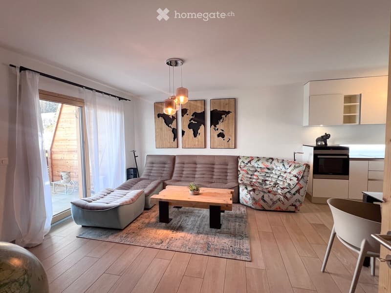 modern living room with wooden floor, large windows, sliding glass door, sofa, coffee table, rug, pendant lights, world map wall art, kitchen with oven, dining table, chair