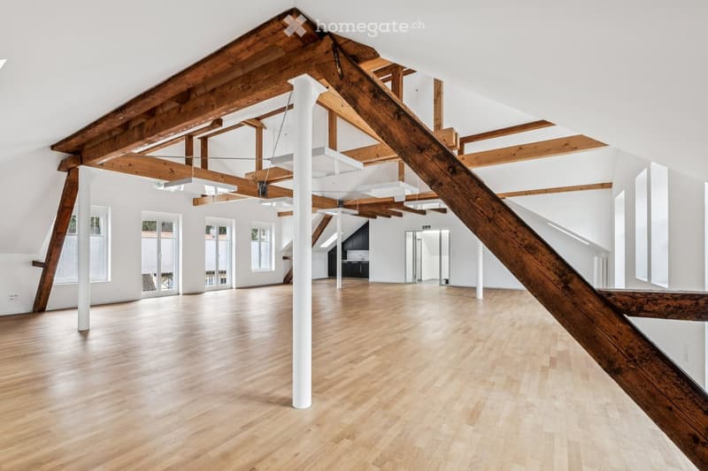 large open space, wooden beams, white walls, hardwood floors, windows, ceiling lights
