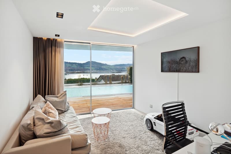 modern living room with large windows, couch, two tables, pool view