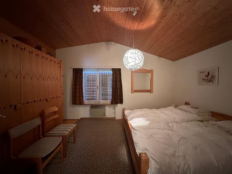 bedroom with wooden bed, wooden chairs, wooden cabinet, carpeted floor, wooden ceiling, window with curtains, mirror, picture frame