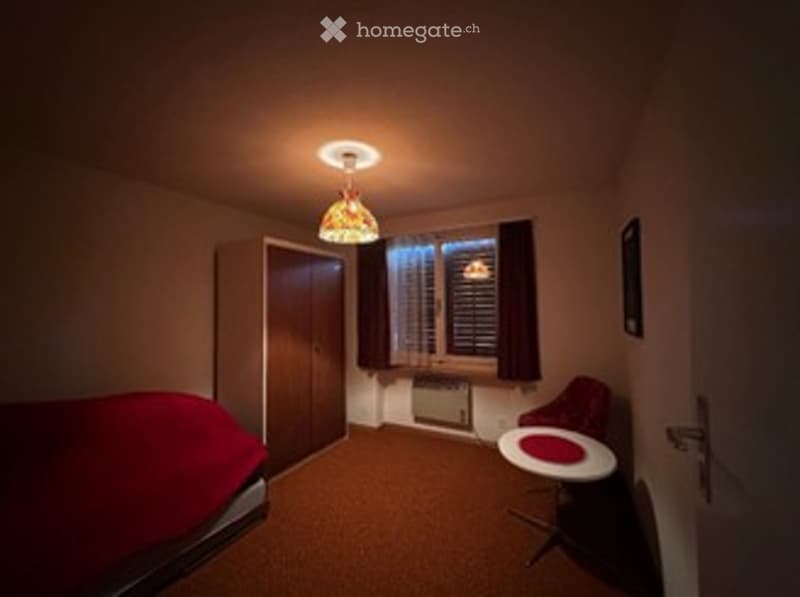 bedroom with bed, wardrobe, table, chair, lamp, window with blinds