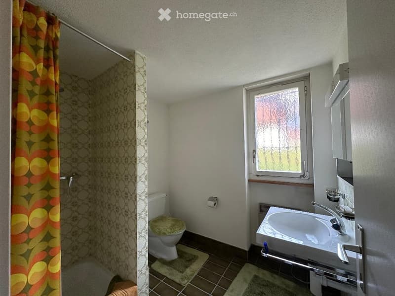 Bathroom with shower, toilet, sink, and window